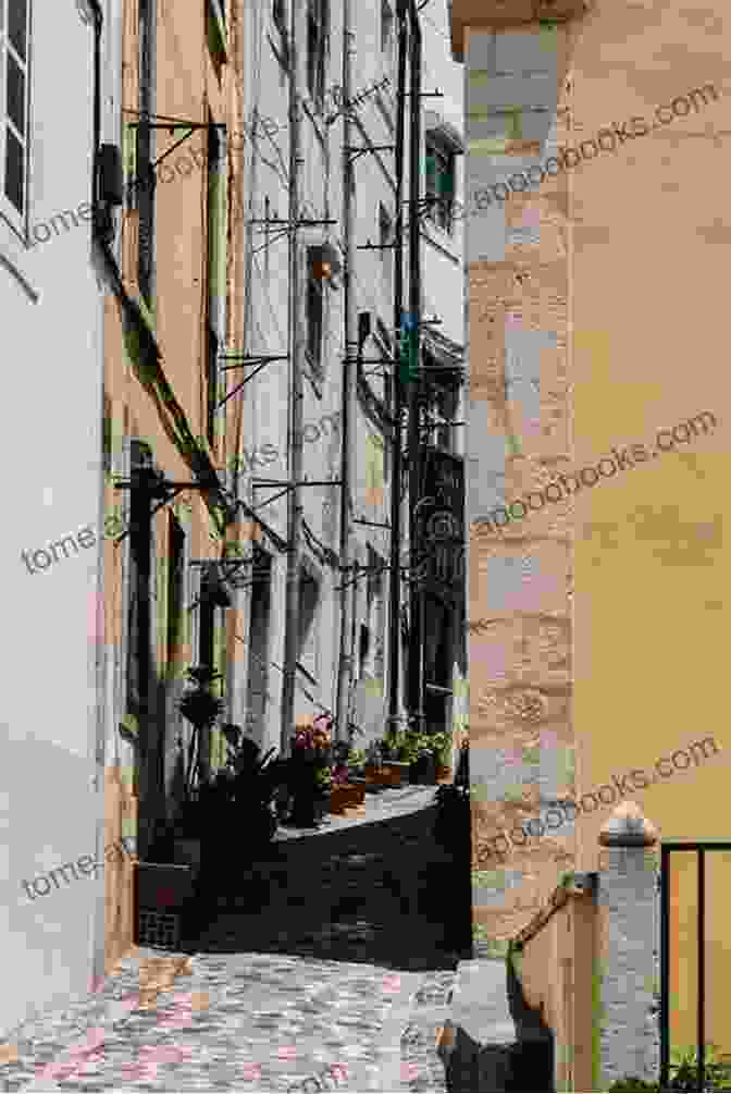 A View Of Narrow Cobblestone Streets And Old Buildings In Lisbon, With People Walking And Sitting Outside Cafes The Year Of The Death Of Ricardo Reis (Harvest In Translation)